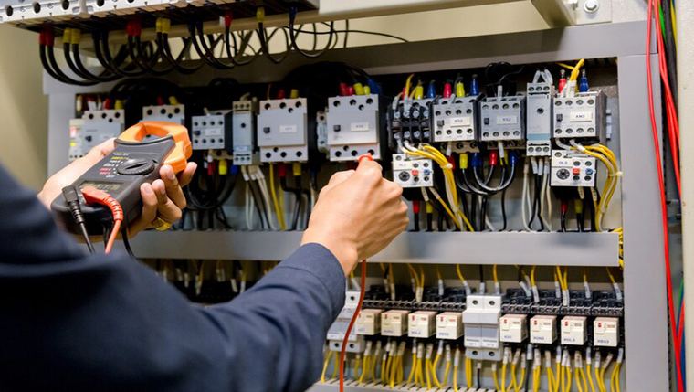 Technician testing an electrical panel
